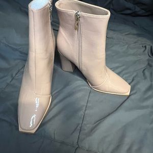 A pair of faux patent leather booties